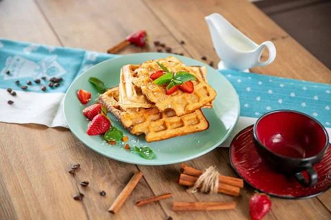 Breakfast with waffles, strawberries, mint and cinnamon Stock Photos