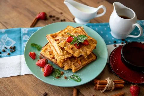 Breakfast with waffles, strawberries, mint and cinnamon Stock Photos