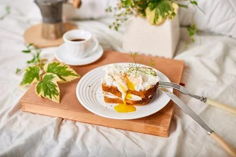 Breakfast on white bed sheets, good morning, toast with poached eggs, coffee Stock Photos