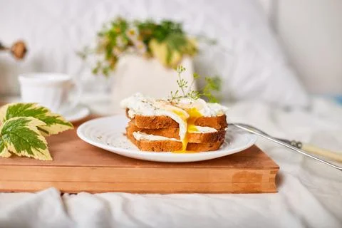Breakfast on white bed sheets, good morning, toast with poached eggs, coffee Stock Photos