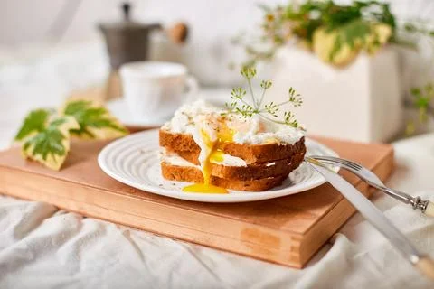 Breakfast on white bed sheets, good morning, toast with poached eggs, coffee Stock Photos