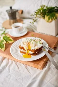 Breakfast on white bed sheets, good morning, toast with poached eggs, coffee Foto stock