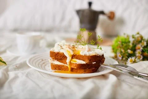 Breakfast on white bed sheets, good morning, toast with poached eggs, coffee Stock Photos