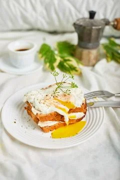 Breakfast on white bed sheets, good morning, toast with poached eggs, coffee Foto stock