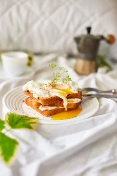 Breakfast on white bed sheets, good morning, toast with poached eggs, coffee Stock Photos