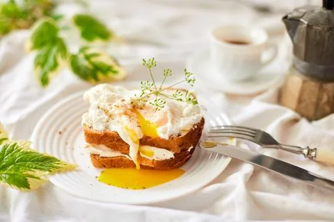 Breakfast on white bed sheets, good morning, toast with poached eggs, coffee Stock Photos