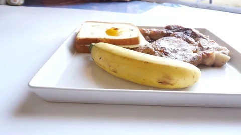 Breakfast,Include,pork steak,Fried egg, bread and banana Stock Footage 70114275