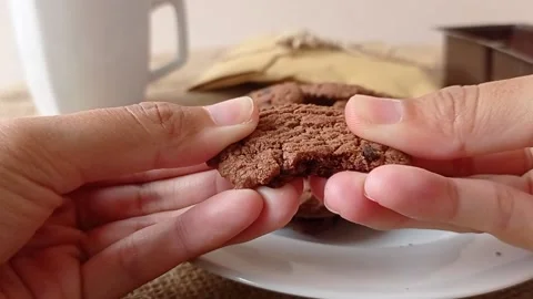 Breaking the biscuit before eating it Stock Footage 150398960