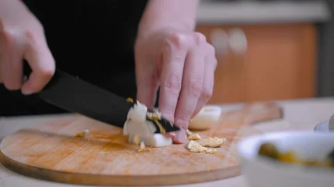 Breaking boiled eggs into small pieces on wooden board nearby mayo bowl Stock Footage 328494924