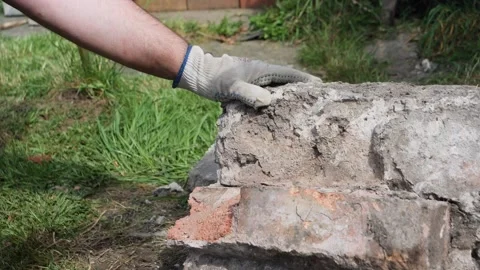 Breaking bricks out of concrete with lump hammer in slow motion Video stock 275297700