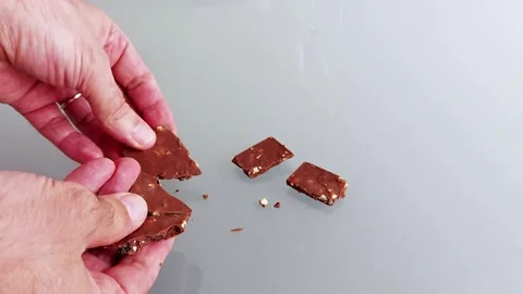 Breaking Chocolate Bars by Hand: Crisp Texture on Glossy Surface Vídeos de archivo 314545491