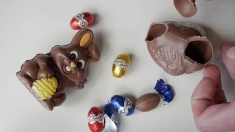 Breaking Chocolate Bunny with Colorful Easter Eggs for Festive Celebration Stock Footage 331903960