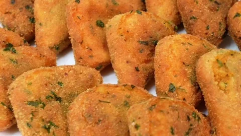 Breaking a crispy fried potato triangle snack to show the soft inside texture Stock Footage 325071909