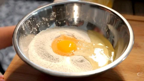 Breaking an egg in the bowl with flour. Video stock 103564602