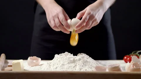 Breaking An Egg That Falls On A Pile Of White Flour On Wooden Board On Table Video stock 170238897