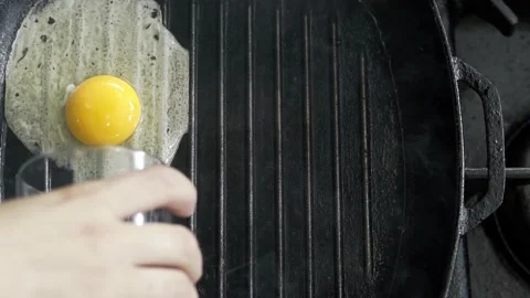 Breaking Egg On Frying Pan. Egg falling on hot frying pan in slow motion. Stock Footage 238625432