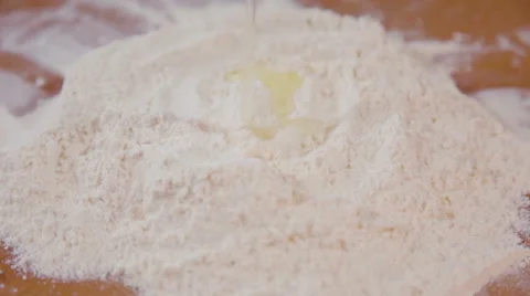 Breaking an egg onto heap of flour Stock Footage 62398762