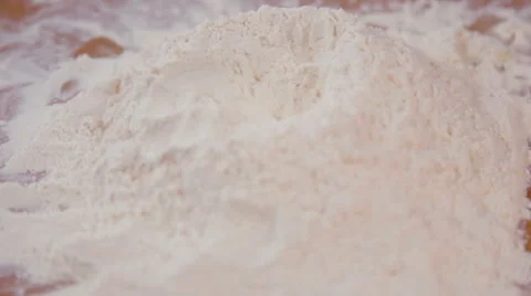 Breaking an egg onto heap of flour Stock Footage 62398807