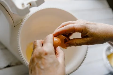 Breaking an egg inside a kneader mixer Fotos de archivo