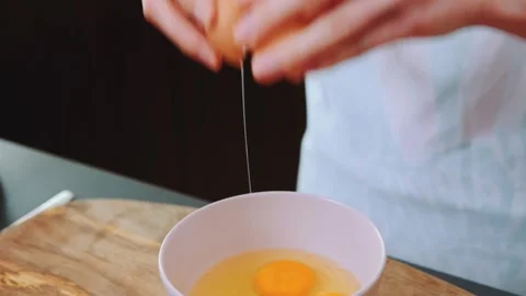 Breaking an egg into a plate Stock Footage 252204349