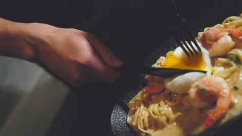 Breaking Egg Yolk over Spaghetti on Dining Table Close Up Stock Footage 335732735