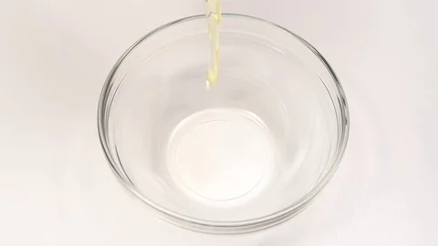 Breaking eggs for cooking in glass deep dish, slow motion Stock Footage 76145921