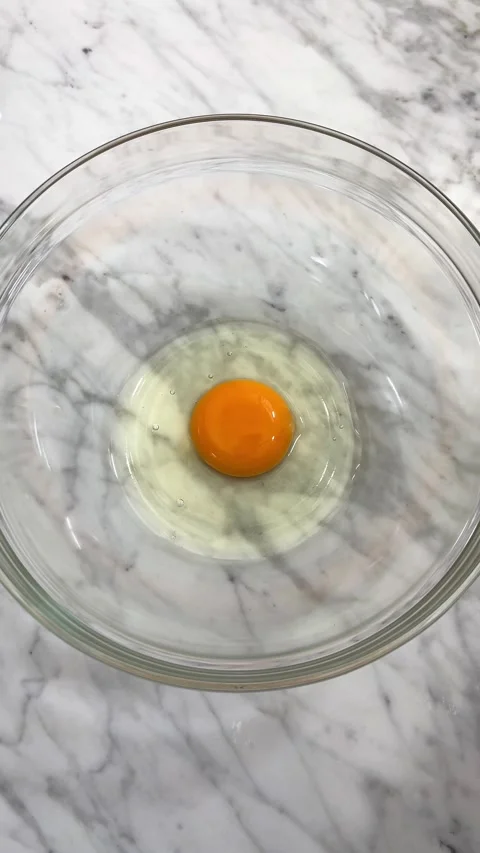 Breaking eggs for food preparation Stock Footage 286359392