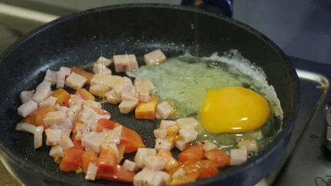 Breaking Eggs into Fried Vegetables in a frying Pan Stock Footage 98151086
