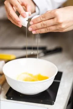 Breaking eggs for making custard Stock Photos