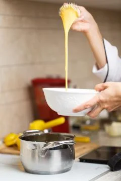 Breaking eggs for making custard Stock Photos