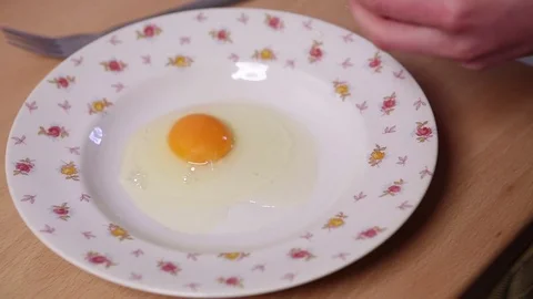 Breaking eggs on a plate Stock Footage 76361146