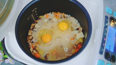 Breaking eggs into rice with vegetables Stock Footage 249583991