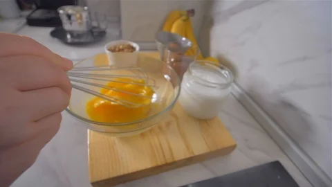 Breaking the eggs with a whisk. Making pancakes. Stock Footage 113057269