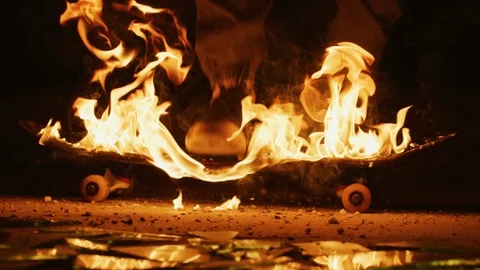 Breaking a flaming skateboard Stock-Footage 100053997