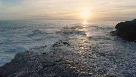 Breaking Foaming Wave to Reef Rock Shallow with Mountain Landscape Before Sunset Stock Footage 128946763