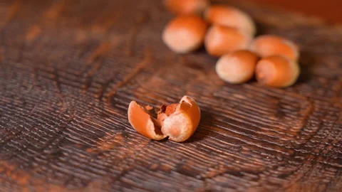 Breaking hazelnuts with a hammer on the wooden table Stock Footage 248153123
