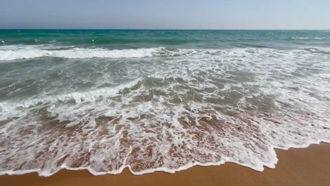 Breaking Mediterranean waves washing onto a sandy beach on a sunny summer day. Stock Footage 341409926