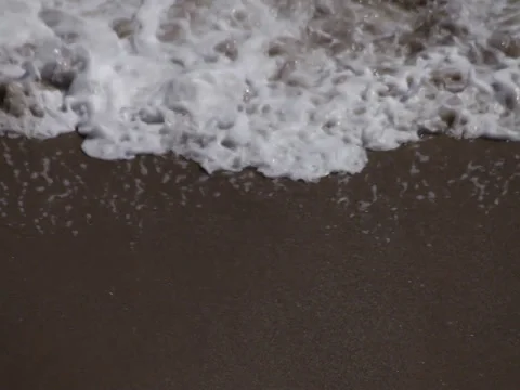 Breaking ocean lace foam whitecap waves washing shore beach sand Stock Footage 37692686