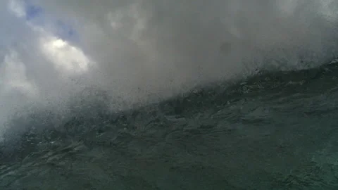 Breaking Ocean Wave Surging Beneath Dense Gray Clouds and Mist Stock Footage 344383032