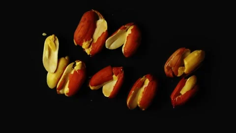 Breaking Organic Peanuts out of shell in black dark background. 4K Stock Footage 150239240