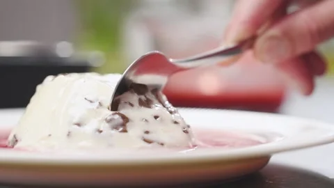 Breaking off a piece of stracciatella panna cotta with a spoon. Stock Footage 157540285