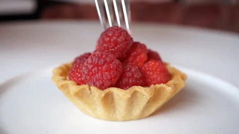 Breaking a raspberry cake with a dessert fork and knife Stock Footage 117696548