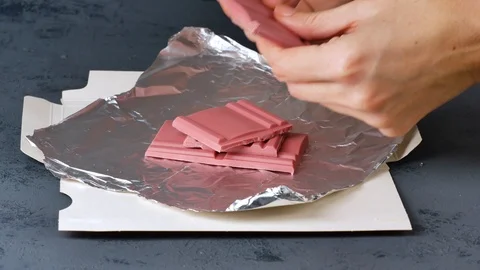 Breaking Ruby chocolate bar on pieces. New dimension of chocolate sweets. Video stock 124888855