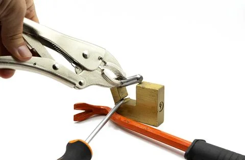 Breaking a security padlock with tools, a screwdriver, a wrench and a kicks.. Photos