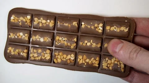 Breaking off slices from a bar of chocolate on a white background. Stock Footage 164106944