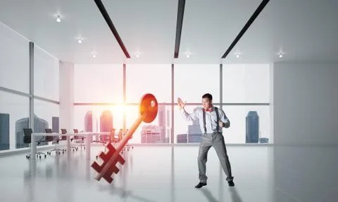 Breaking through access concept with furious man crashing concrete key 스톡 사진
