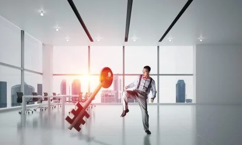 Breaking through access concept with furious man crashing concrete key 스톡 사진