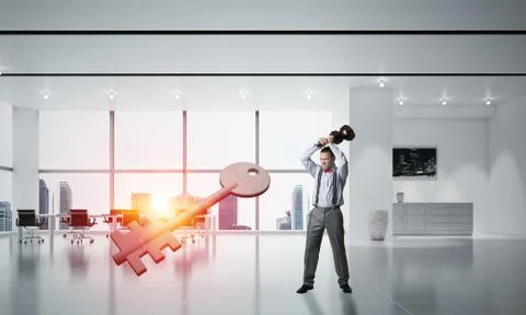 Breaking through access concept with furious man crashing concrete key Stock Photos