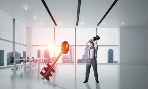 Breaking through access concept with furious man crashing concrete key Stock Photos