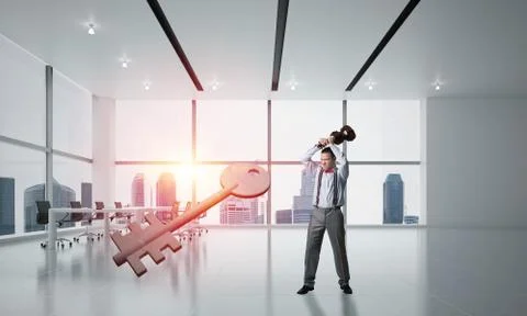Breaking through access concept with furious man crashing concrete key 스톡 사진
